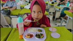 Foto: Siswa-siwi menyantap hidangan makan bergizi saat uji coba program makam bergizi gratis.