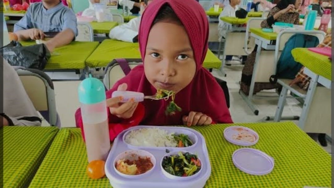 Foto: Siswa-siwi menyantap hidangan makan bergizi saat uji coba program makam bergizi gratis.